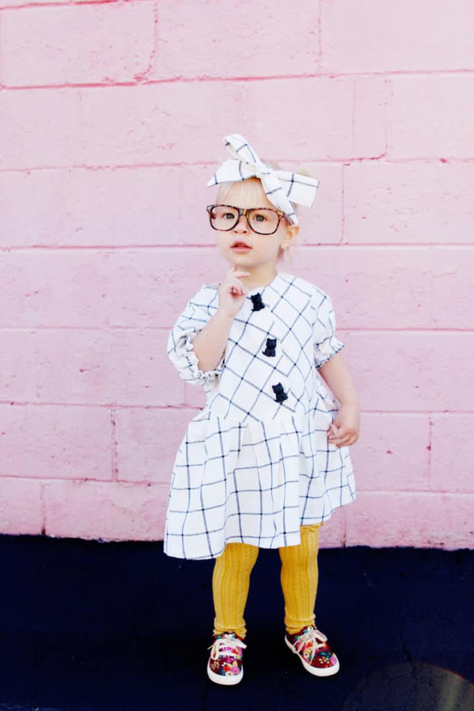 Zig Zag Dress pattern gives a preppy look with it's plaid and pleats! It's curved bodice gives it a really cute swing! Elastic sleeves, big buttons, and facing on the inside makes this dress a dress to love! || See Kate Sew #dresspatterns #kidsfashion #dresses #seekatesew