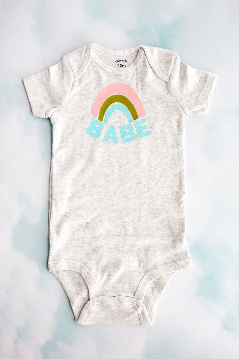 Make this easy Rainbow Baby Onesie with a blank onesie and this free SVG file. Choose a cute onesie with 3 colors of iron-on vinyl and you have a perfect gift for a sweet rainbow baby or your own sweet rainbow babe! || See Kate Sew #rainbowbaby #babyonesies #cricutprojects #freesvg #seekatesew